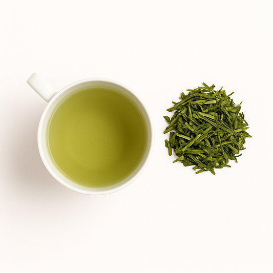 Cup of bright green sencha tea with loose leaves on a ceramic tray; Japanese green tea rich in EGCG for skin protection and antioxidant defense