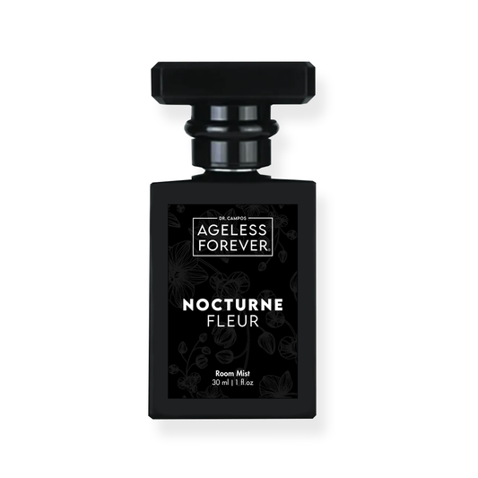 Black glass spray bottle labeled Nocturne Fleur beside floral accents; luxury room mist with skin-safe botanical fragrance